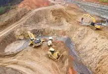 top view photography of four heavy equipment on quarry at daytime
