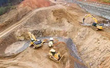 top view photography of four heavy equipment on quarry at daytime