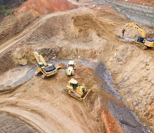 top view photography of four heavy equipment on quarry at daytime