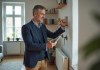 Auditeur énergie inspectant un radiateur avec tablette dans un salon lumineux
