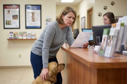 Femme réconfortant son chien à la clinique vétérinaire