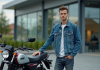 Les meilleures offres pour une moto 125 neuve la plus abordable Jeune homme en denim devant une moto neuve en concession